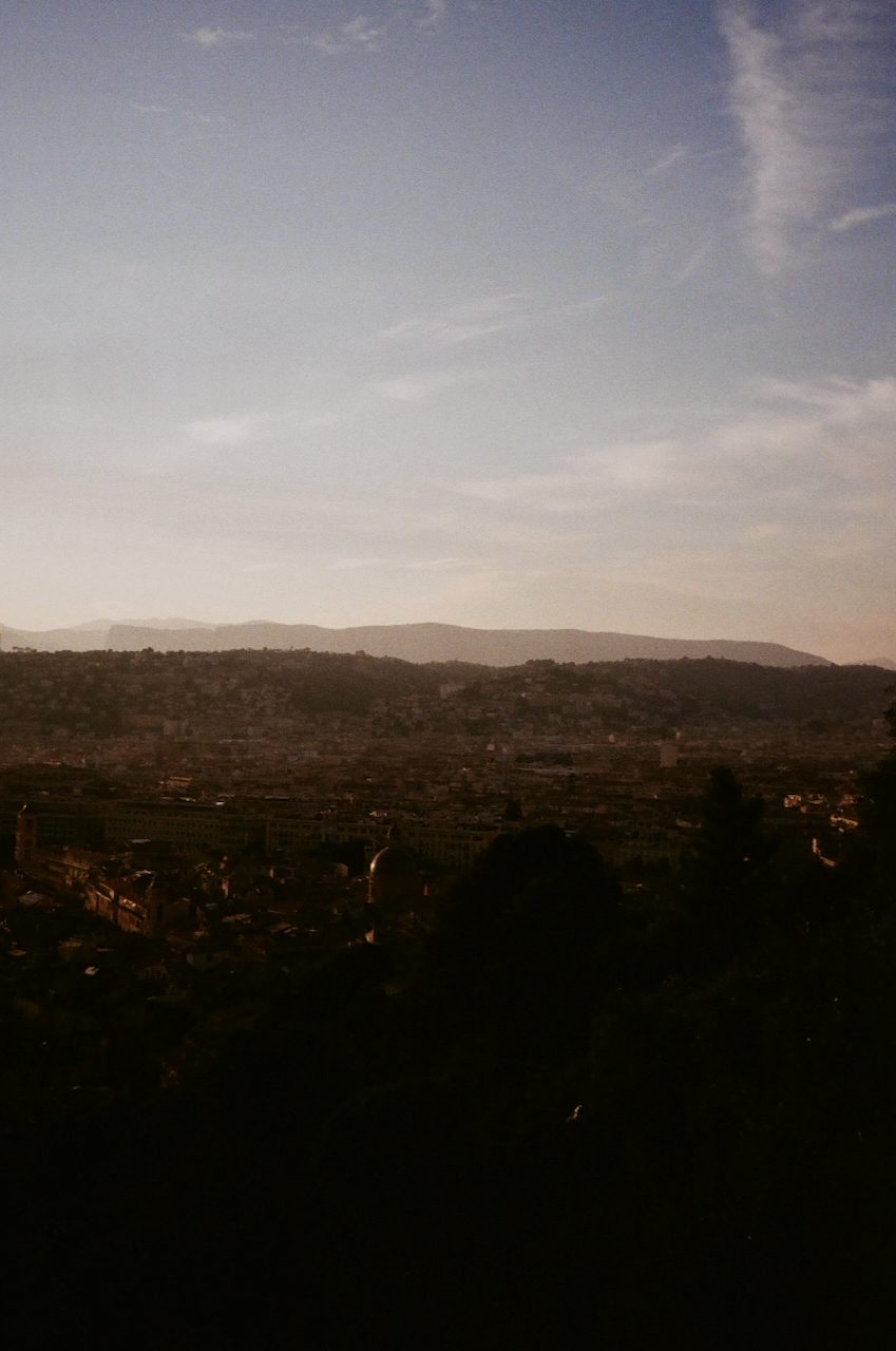 A cityscape with a hazy sky and a distant mountain range