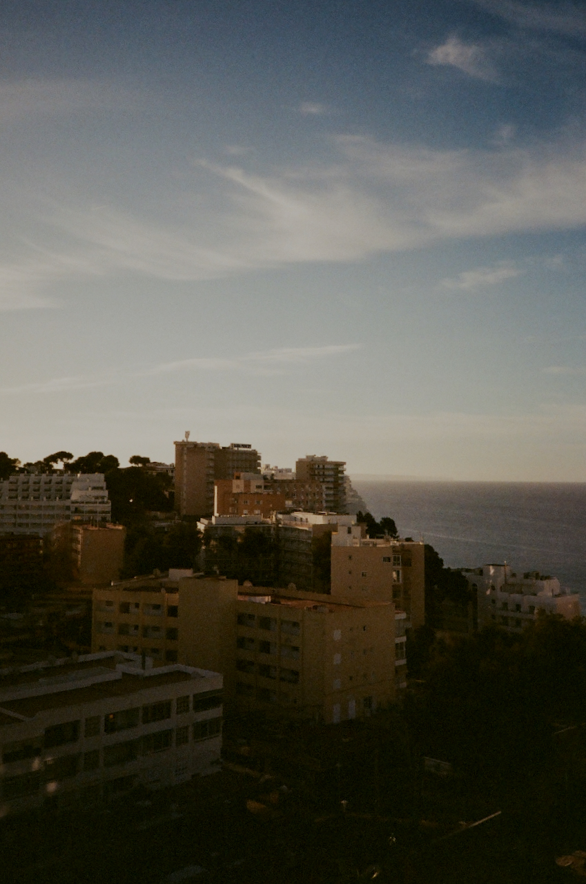 A cityscape with a coastal view, featuring a town with buildings and a clear sky
