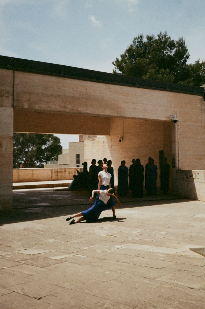 A person is performing a handstand in a courtyard