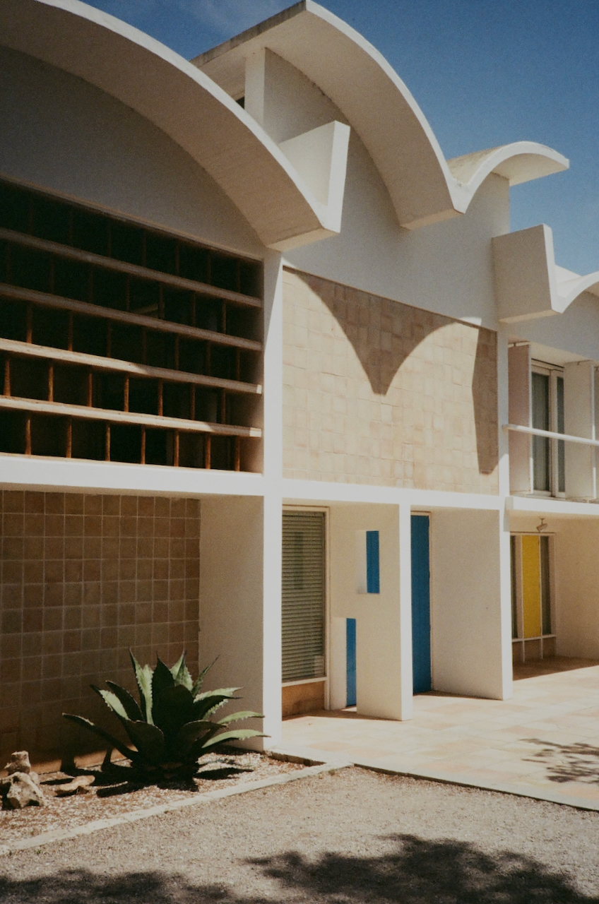 A modern building with a curved roof, set against a clear sky