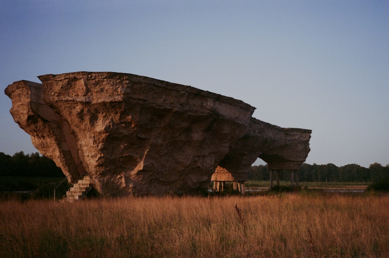 Large rock formation with jagged edges, set against a clear sky