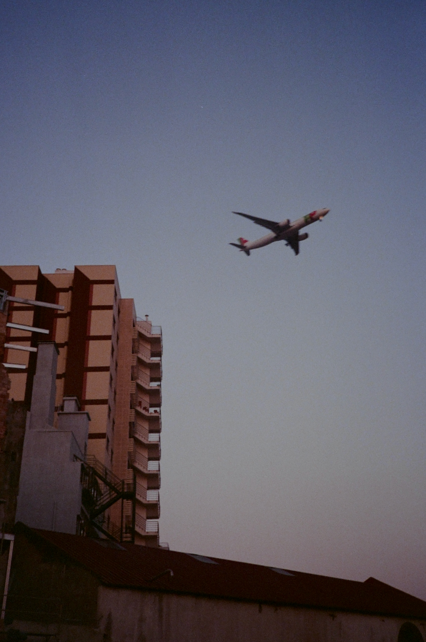 Airplane flying in sky above buildings