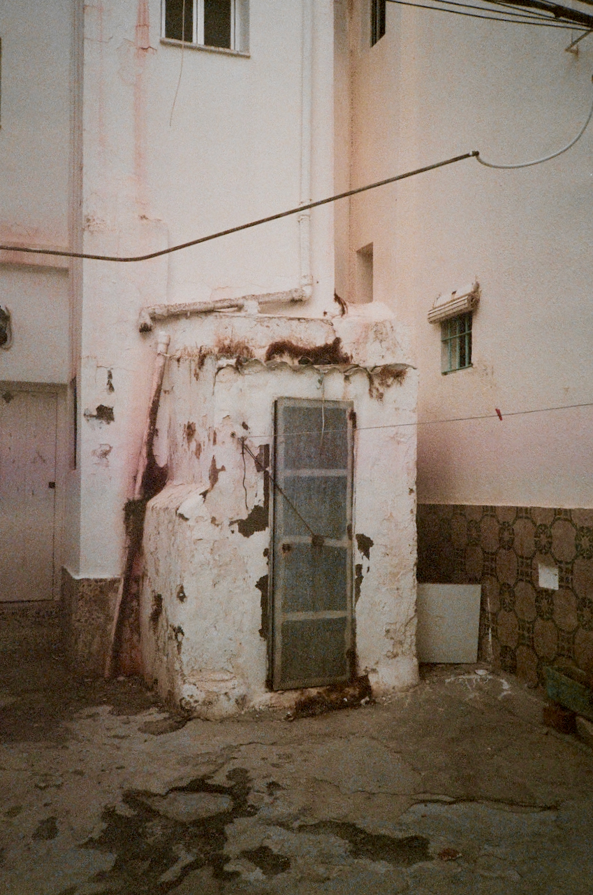 Abandoned building with peeling paint and a rusted metal door