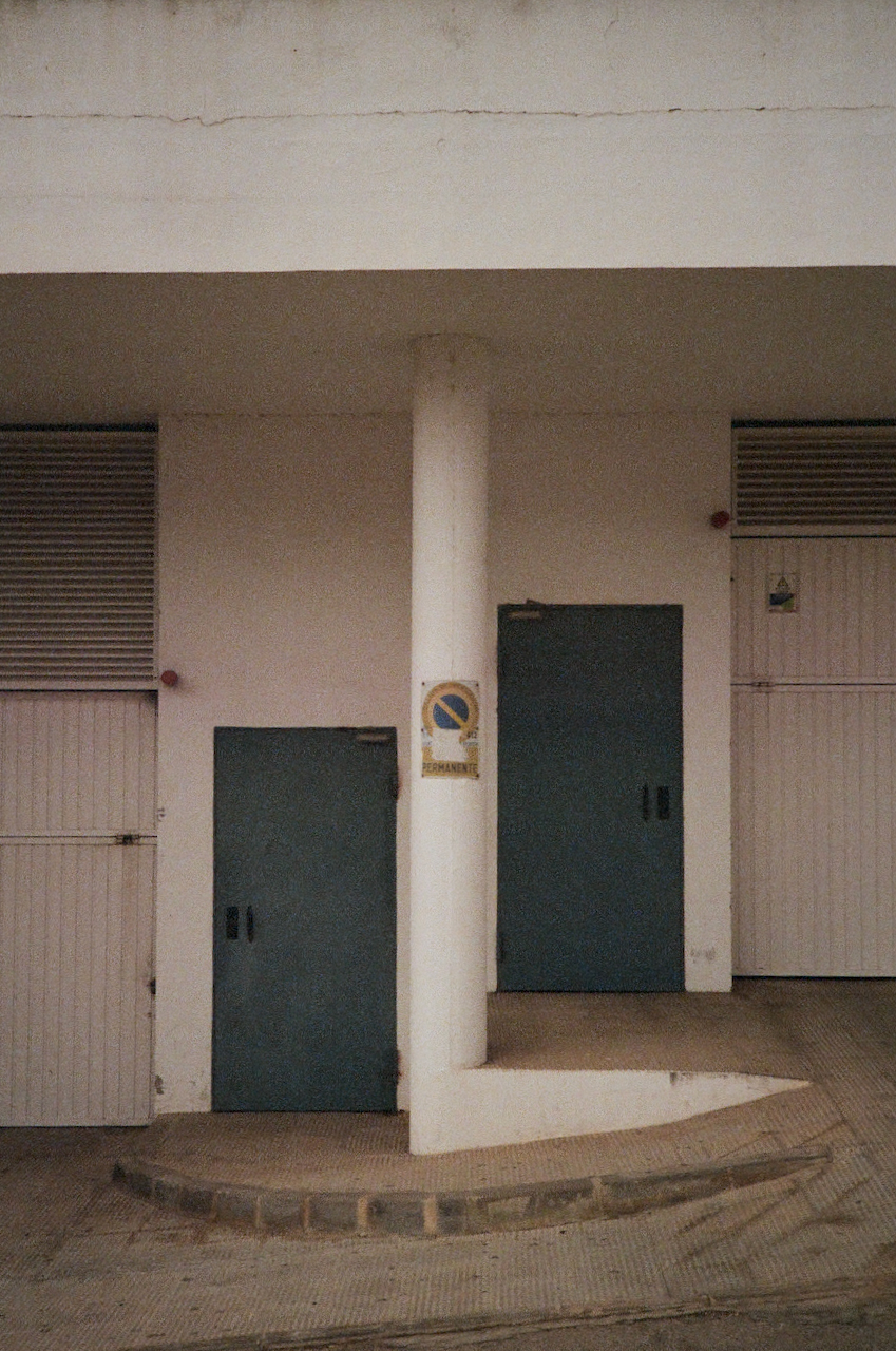A building with a sign, standing alone in a lot