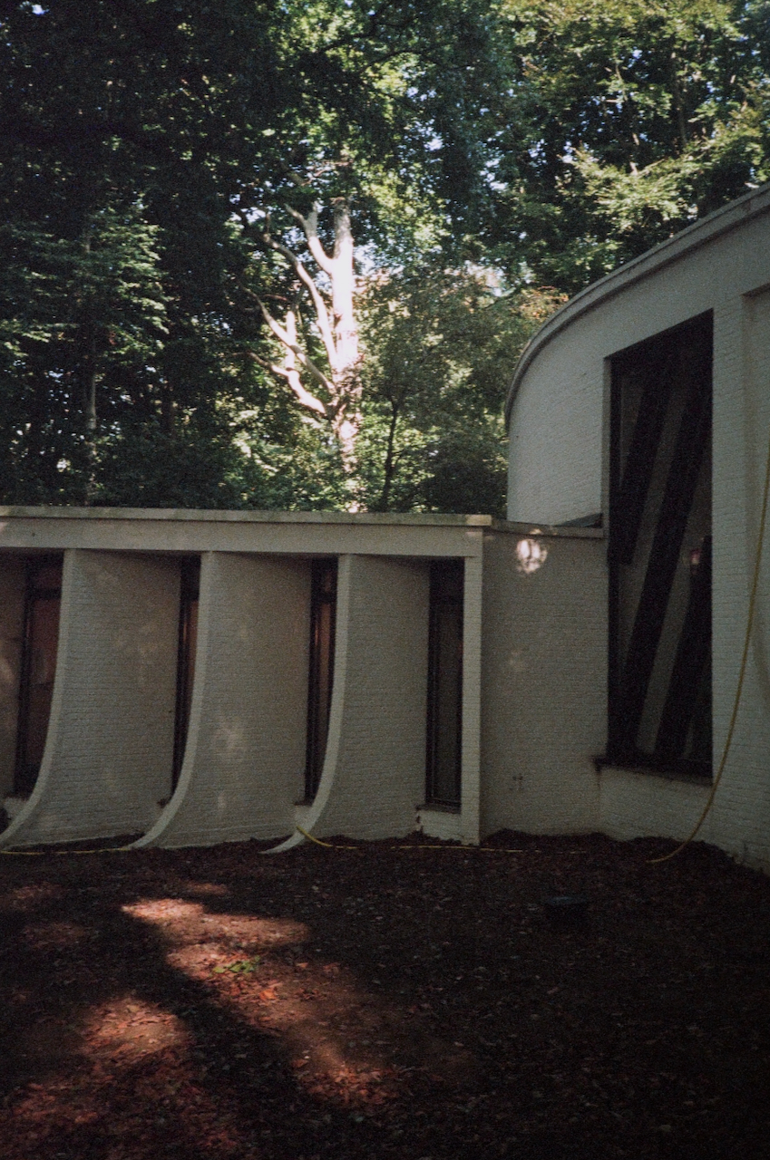 A building with a sloped roof in a wooded area