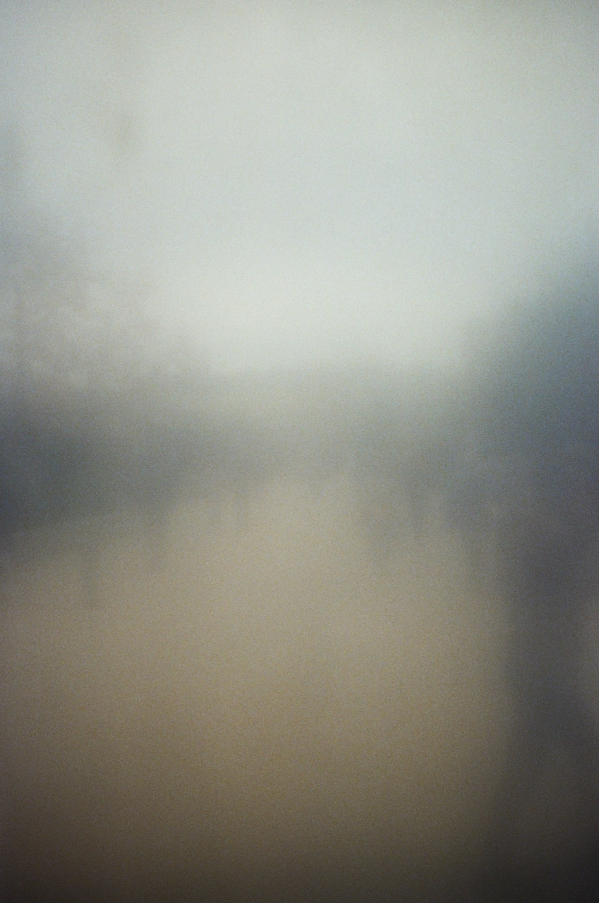 A blurry image of a street with a car in motion