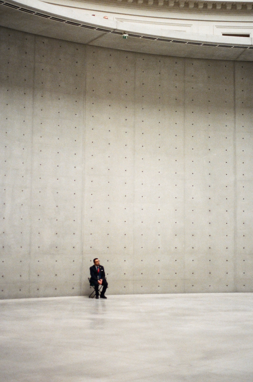 A person standing in a large, empty room with a high ceiling