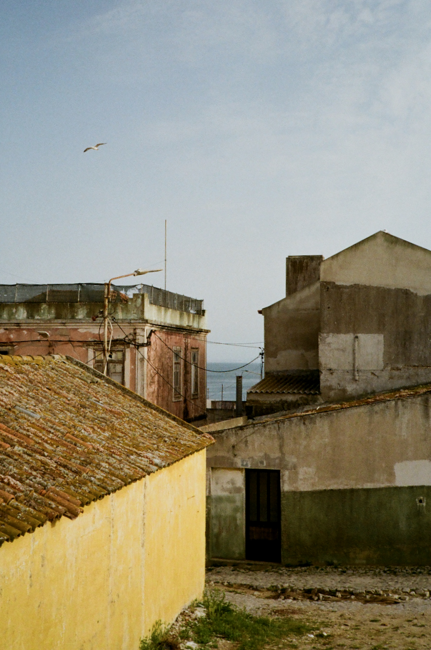 A dilapidated village with yellow buildings and a clear sky