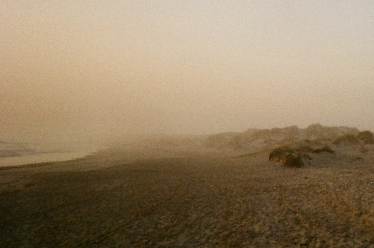 A foggy beach scene with a distant horizon